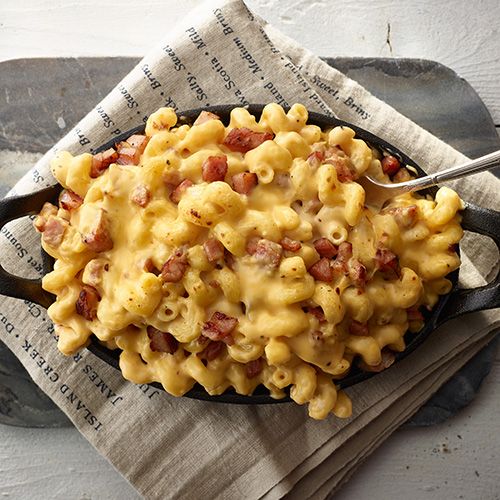 a skillet filled with macaroni and cheese sitting on top of a napkin