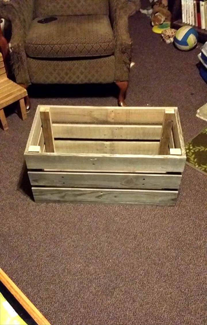 a wooden crate sitting on the floor in front of a chair and couch with other furniture