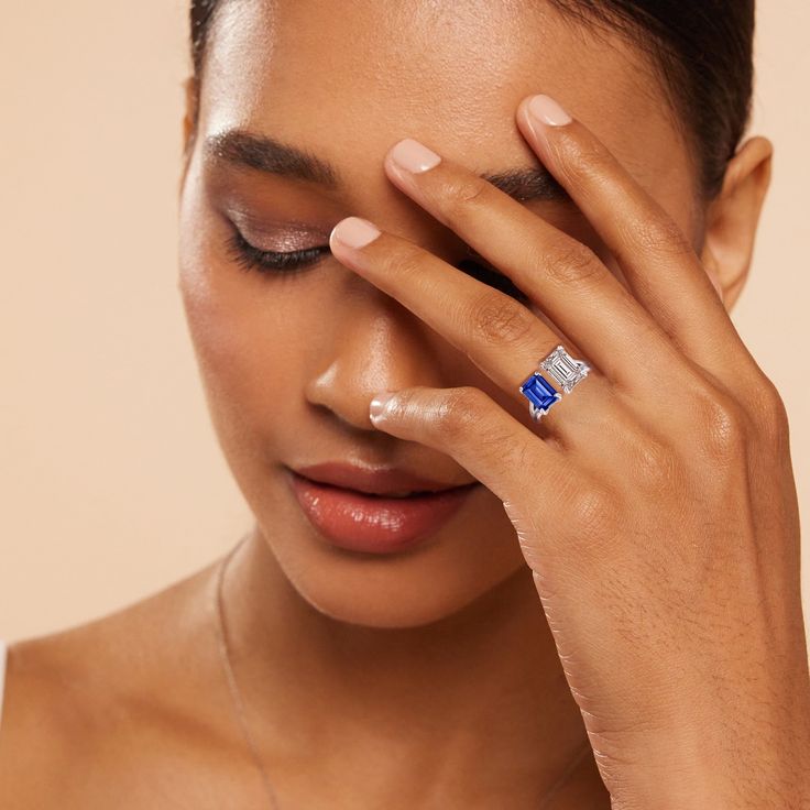 a close up of a woman holding her hand to her face with one eye closed