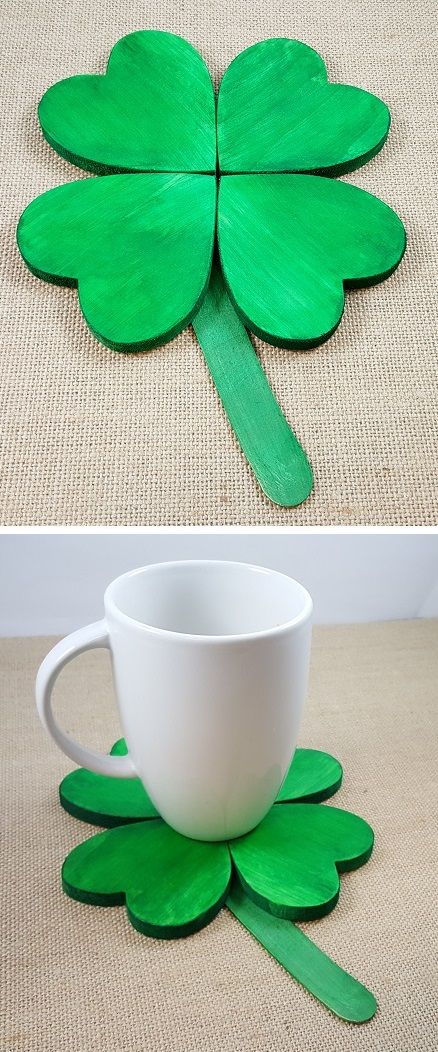 a cup and four leaf clover cut out of wood sitting on top of a table