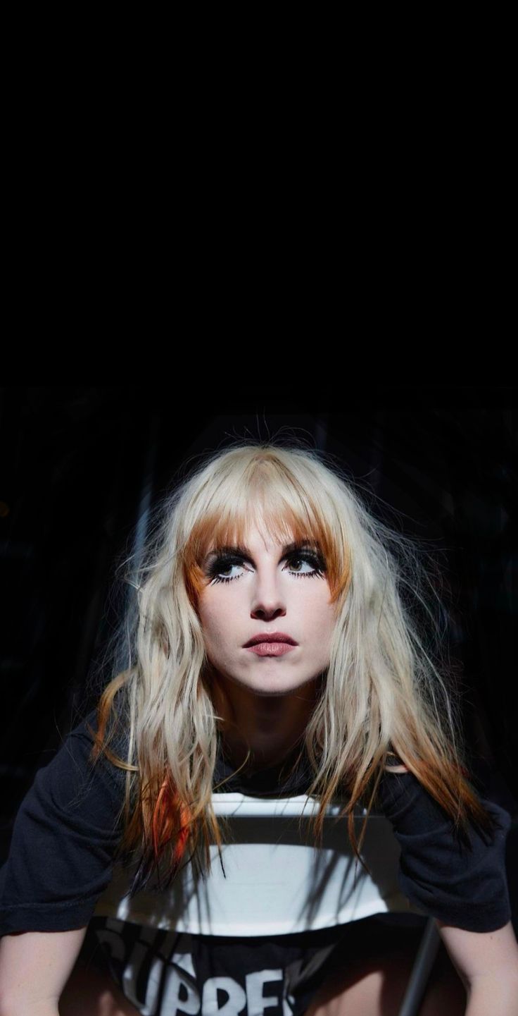 a woman with long blonde hair sitting down