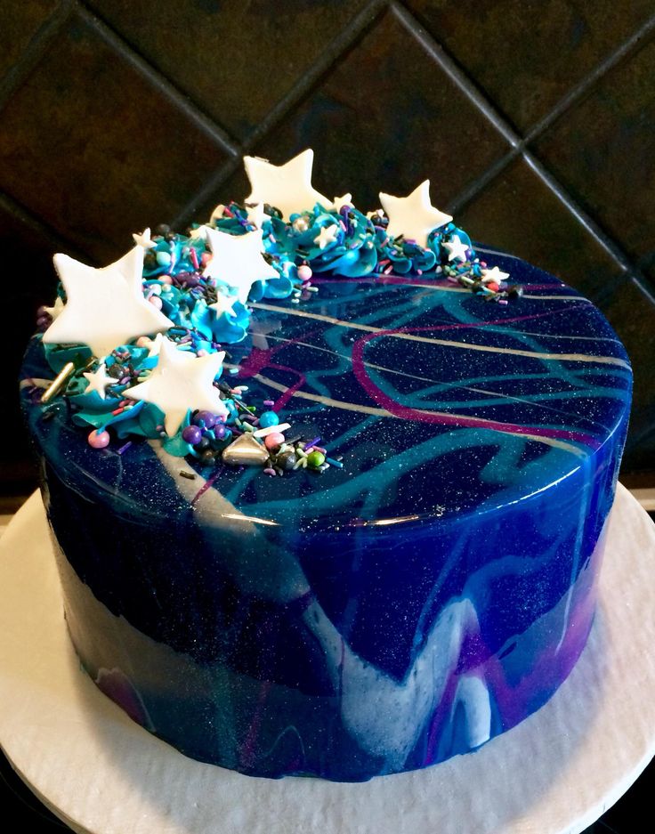 a blue cake with white stars and sprinkles on it's top