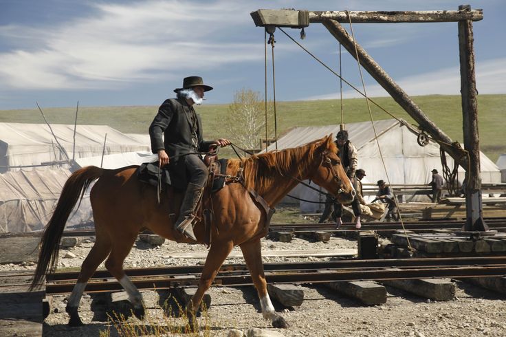 a man riding on the back of a brown horse