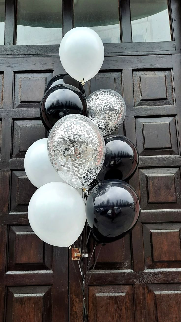 black and white balloons are on the front door