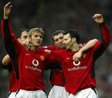 three men in red uniforms standing next to each other with their arms around one another