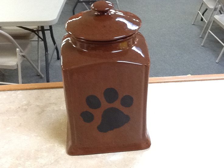 a cookie jar with a paw print on the front and bottom, sitting on a table