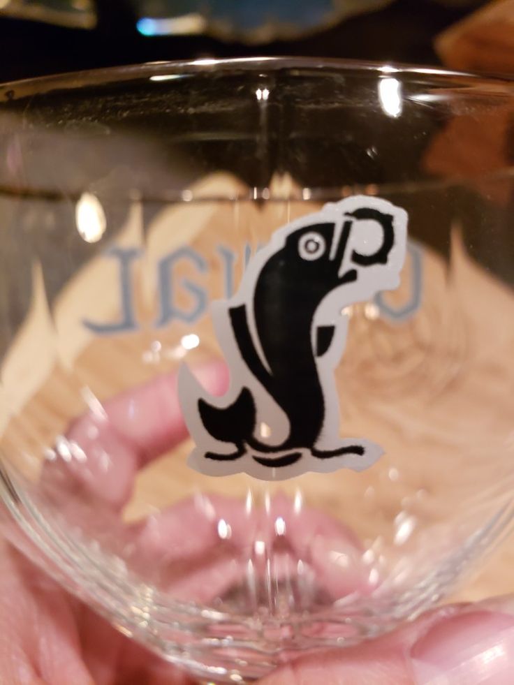 a person holding a wine glass with a sticker on it