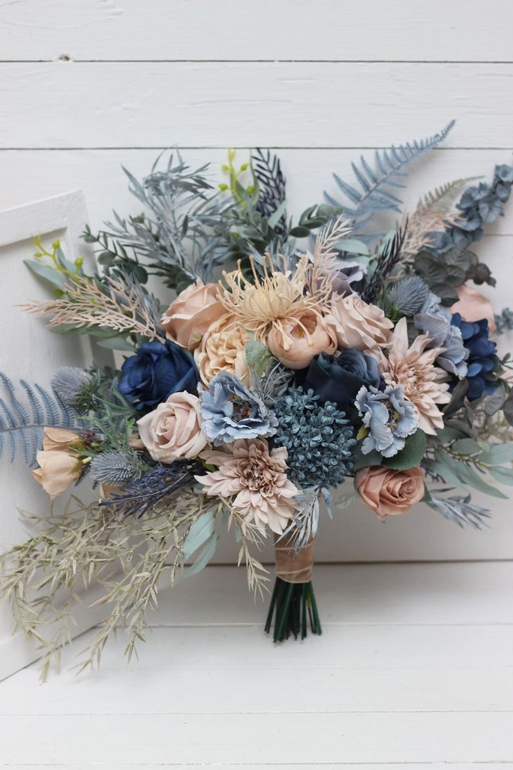 a bridal bouquet with blue and pink flowers on a white background, close up