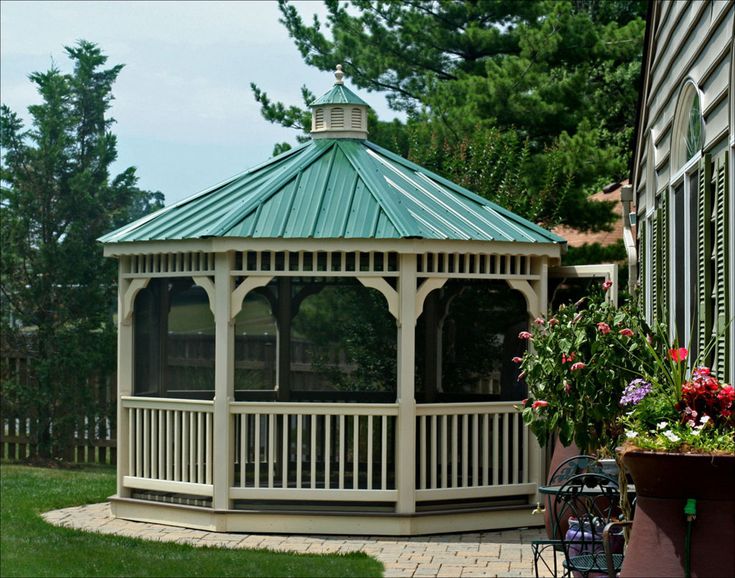 a white gazebo sitting on top of a lush green field