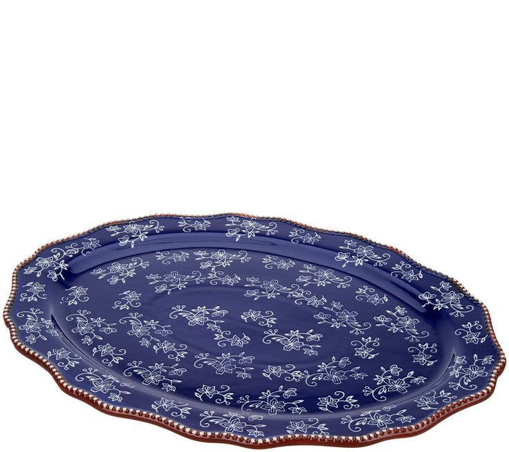 a blue and white platter with floral designs on the rim, set against a white background