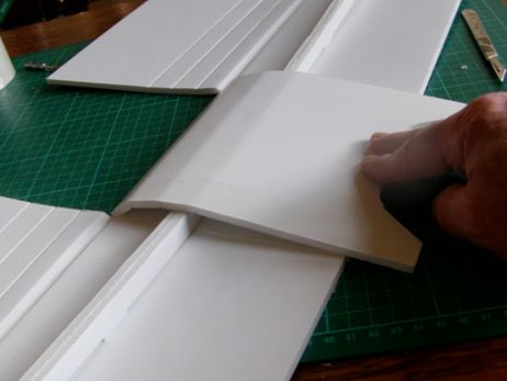 a person cutting out some paper on top of a table