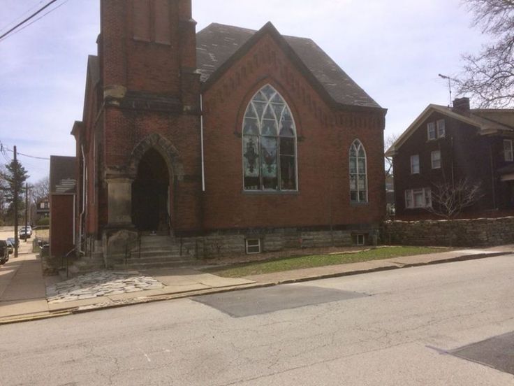 an old red brick church on the corner of a street