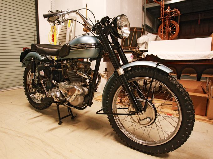 a motorcycle is parked in a garage next to a shelf with boxes and other items