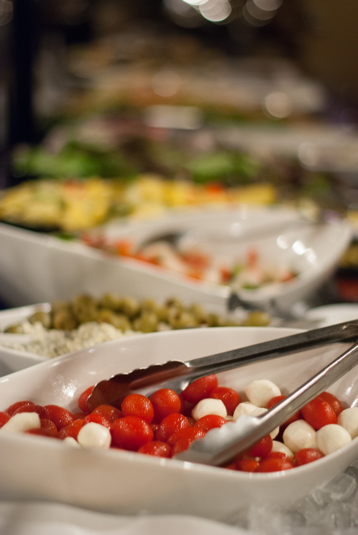 there are many different types of food in the bowls on the table, including tomatoes and mozzarella