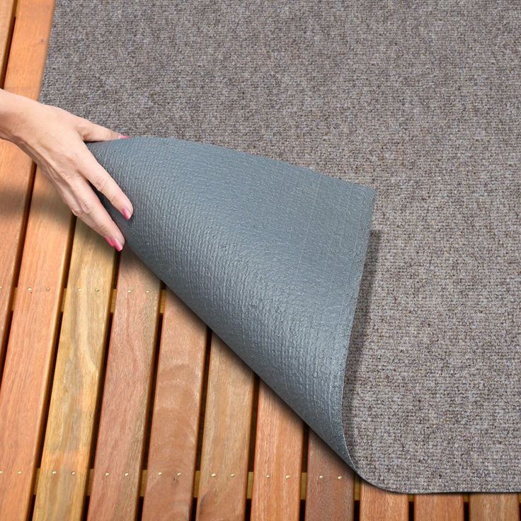 a woman's hand is on the edge of a mat that has been folded over