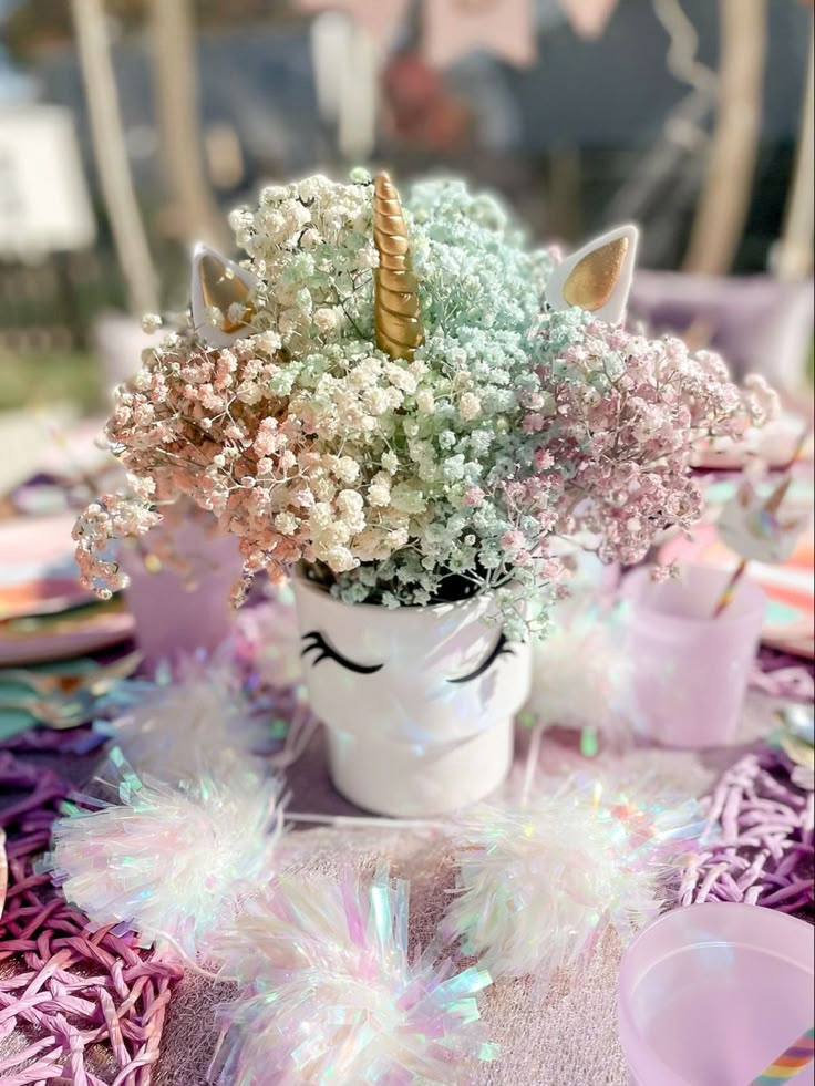 a unicorn themed table setting with pink and white flowers