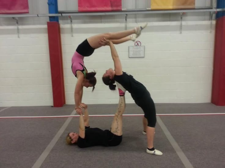 two women doing acrobatic exercises in a gym