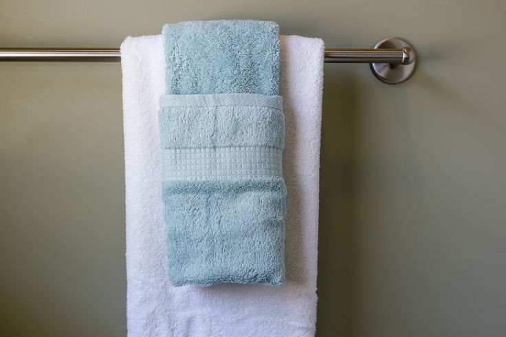 a towel is hanging on the wall next to a towel rack with two folded towels