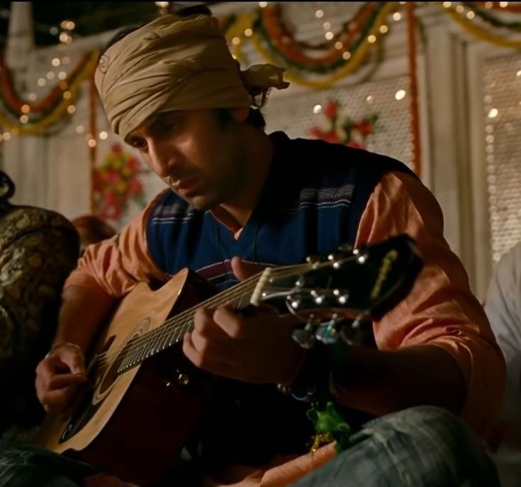 a man with a turban playing an acoustic guitar