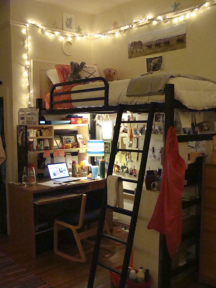 a dorm room with bunk beds, desk and computer on the table in front of it