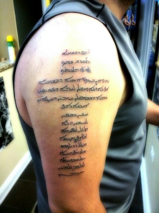 the back of a man's arm with words written in cursive writing