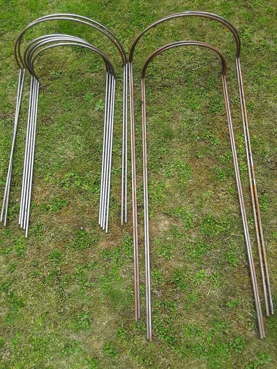 four metal objects laying on the ground in the grass