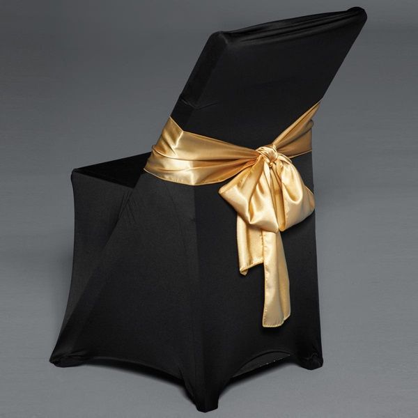 a black chair with gold ribbon tied around the back and seat cover on it's side