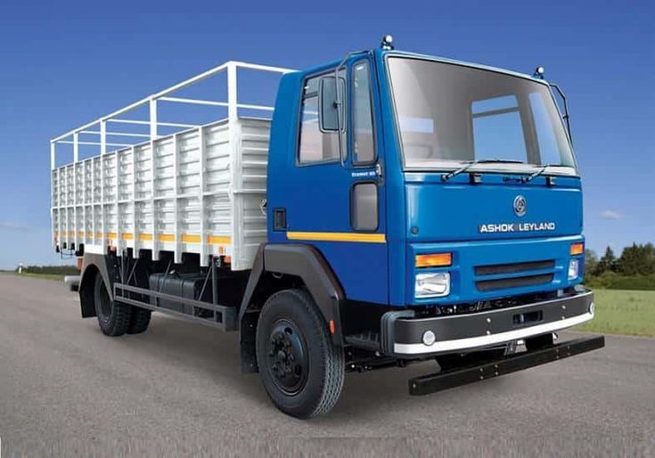 a blue and white truck driving down a road