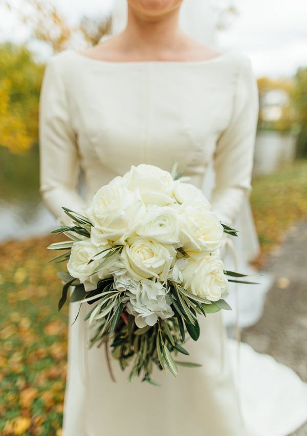 a bride holding a bouquet of white flowers