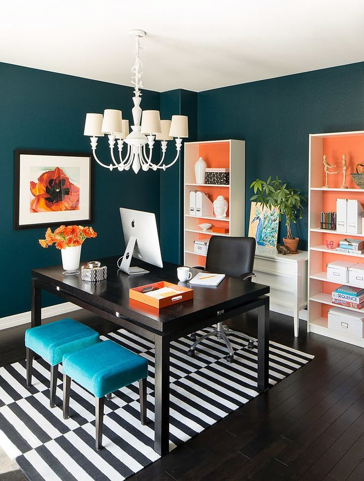 an office with black and white striped rugs, blue walls and a chandelier hanging from the ceiling