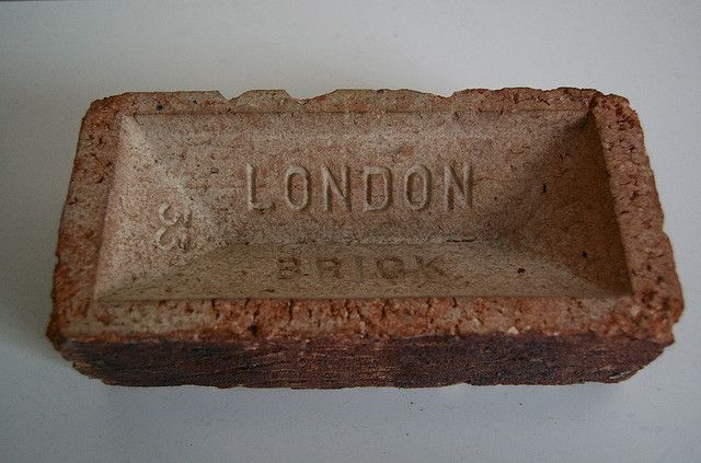 a brick with the word london on it is sitting on a white table next to a wall