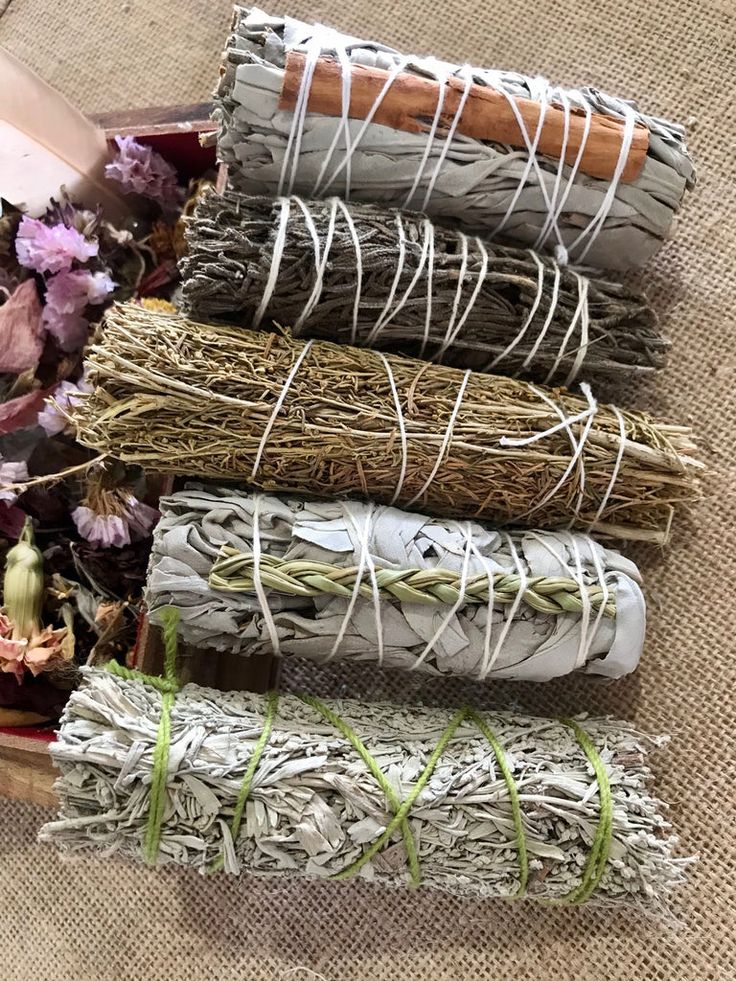 a bunch of different types of fabric on a table with flowers in the middle and one rolled up next to it