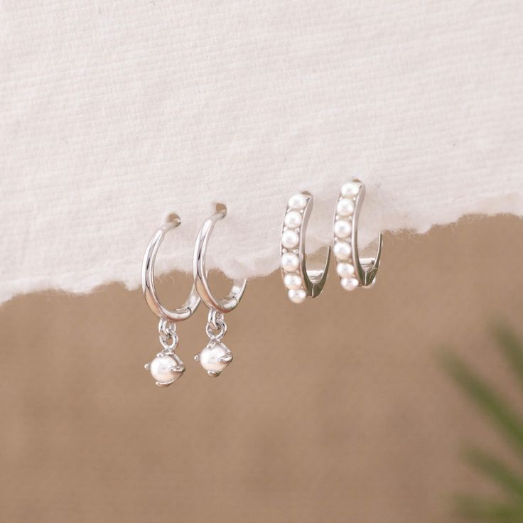 Meet your new everyday treasure: the Dainty Drop Pearl Matching Hoop Gift Set! These perfect pearl hoops are a versatile addition to your stacking hoops collection, thanks to the ideal 8mm and 9mm hoop sizes and tiny ivory pearls that illuminate your everyday look. Made with solid sterling silver, an 18K gold finish, and quality pearls, they are hypoallergenic and water-resistant. Choose a gift set of one or two pairs for your bridesmaids, sister, or loved ones--including yourself! This pearl jewelry will add classic, understated elegance to any outfit. - Material: Hypoallergenic, Solid 925 sterling silver and 18K gold filled finish  Huggie inner diameter: 8.5mm (Style A) / 9mm (Style B) - Turnaround time: Same day or Next day delivery guaranteed  - Qty: Sold as 1 or 2 PAIRS (1 PAIR = 2 EA White Gold Stackable Earrings As Gift, Stackable Sterling Silver Huggie Earrings As Gift, Sterling Silver Stackable Huggie Earrings As Gift, Small Hoop White Cartilage Earrings For Gift, White Dainty Cartilage Earrings For Gift, Dainty White Cartilage Earrings For Gift, Dainty White Cartilage Earrings As Gift, Dainty Sterling Silver Huggie Earrings With Birthstone, Dainty White Sterling Silver Huggie Earrings