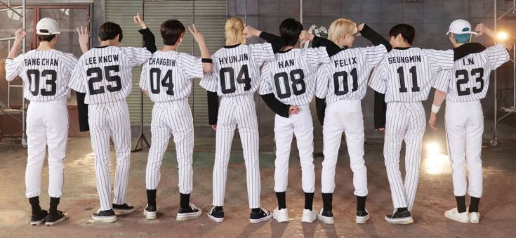 a group of people in baseball uniforms standing next to each other with their hands up