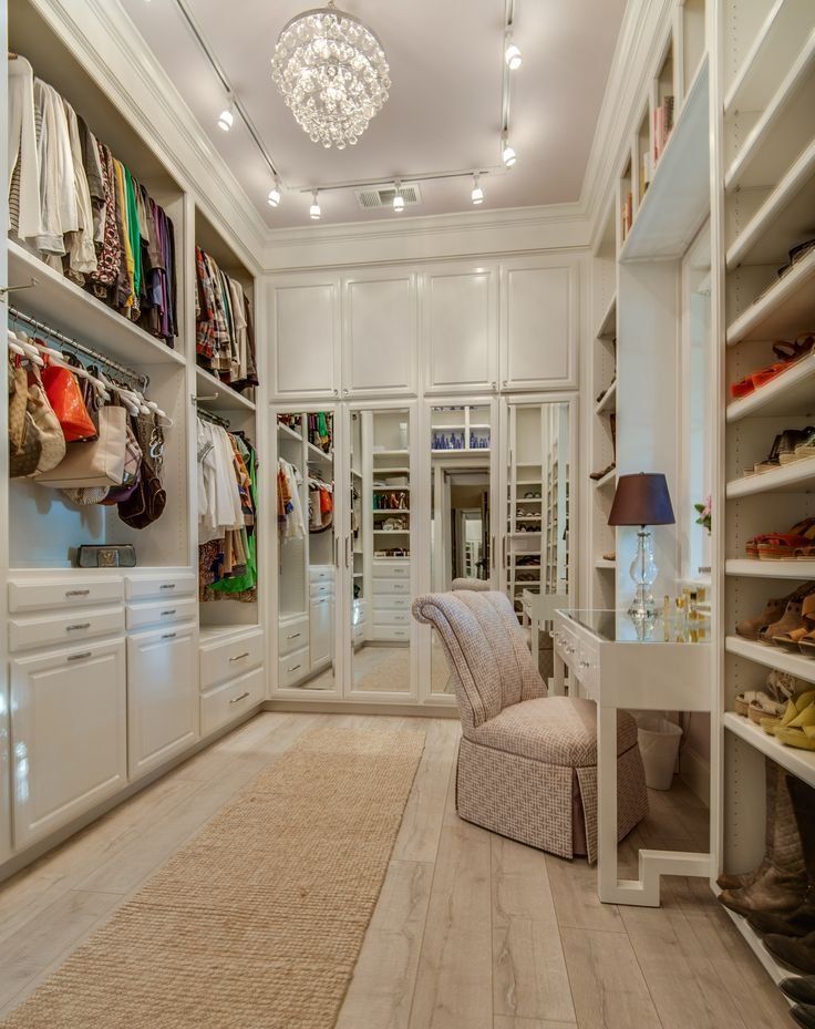 a walk in closet filled with lots of white furniture