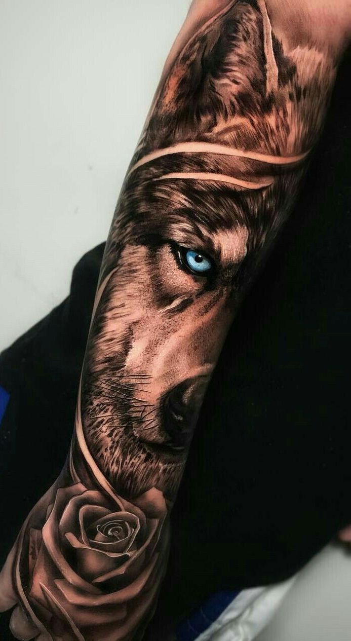 a man's arm with a wolf and rose tattoo on it