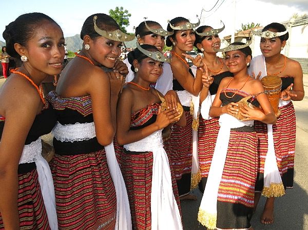 a group of women dressed in native garb posing for the camera with their hands together