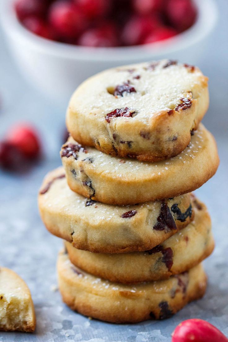 a stack of cookies with cranberries in the background