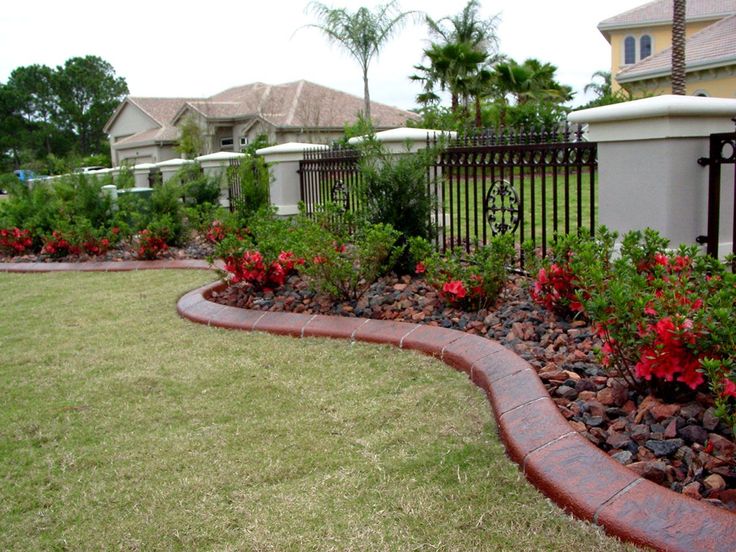 a garden with red flowers and green grass