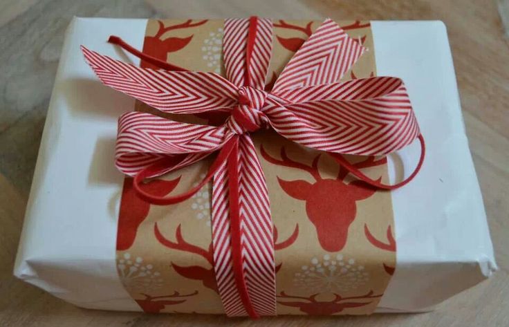 a present wrapped in red and white paper with a bow on it's side