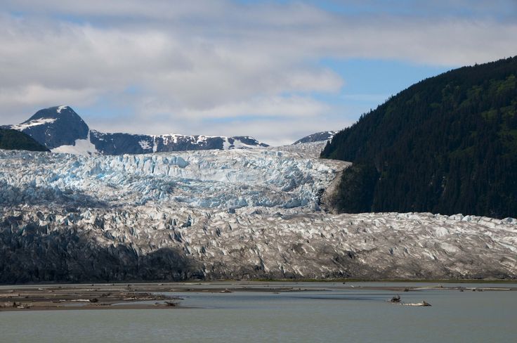 a large glacier with mountains in the background