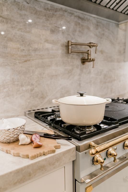 a stove top oven sitting inside of a kitchen next to a counter with a bowl on it