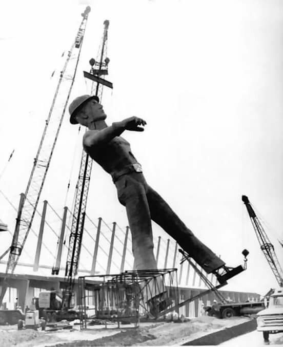 a man on a skateboard doing tricks in the air near construction cranes and buildings