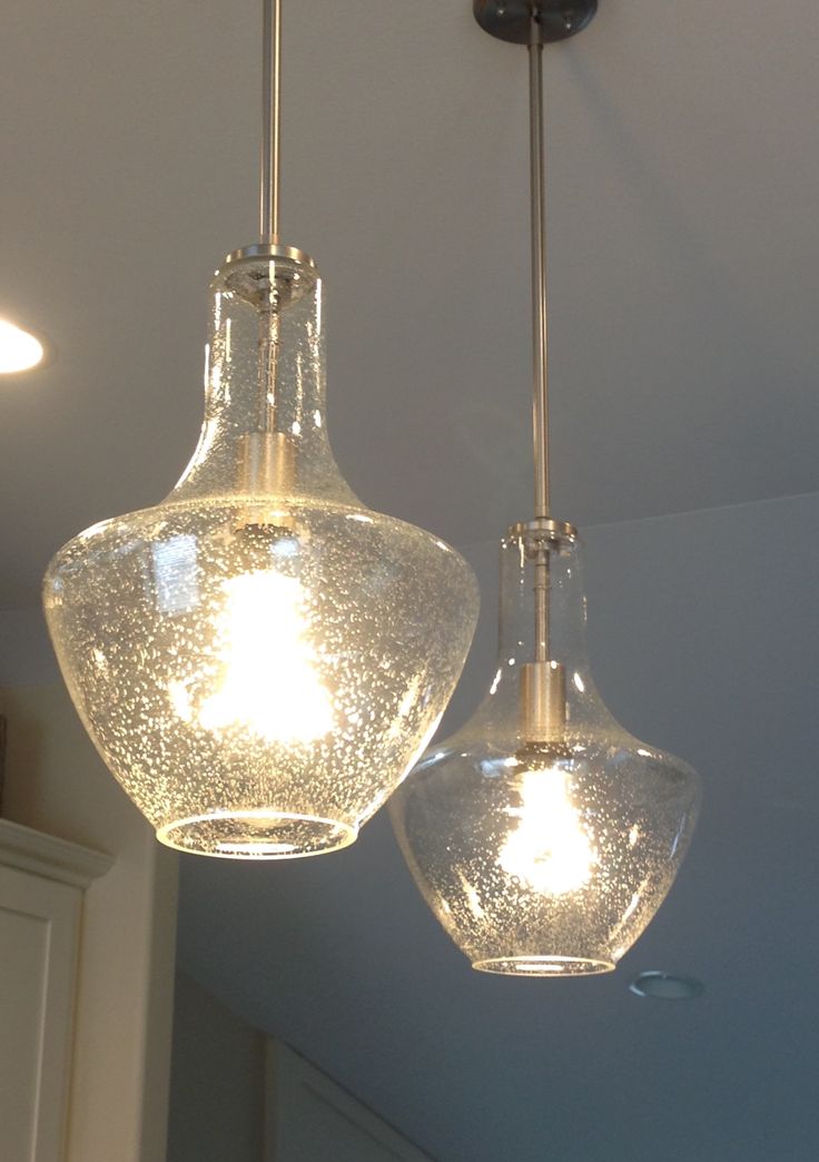 two clear glass lights hanging from a ceiling