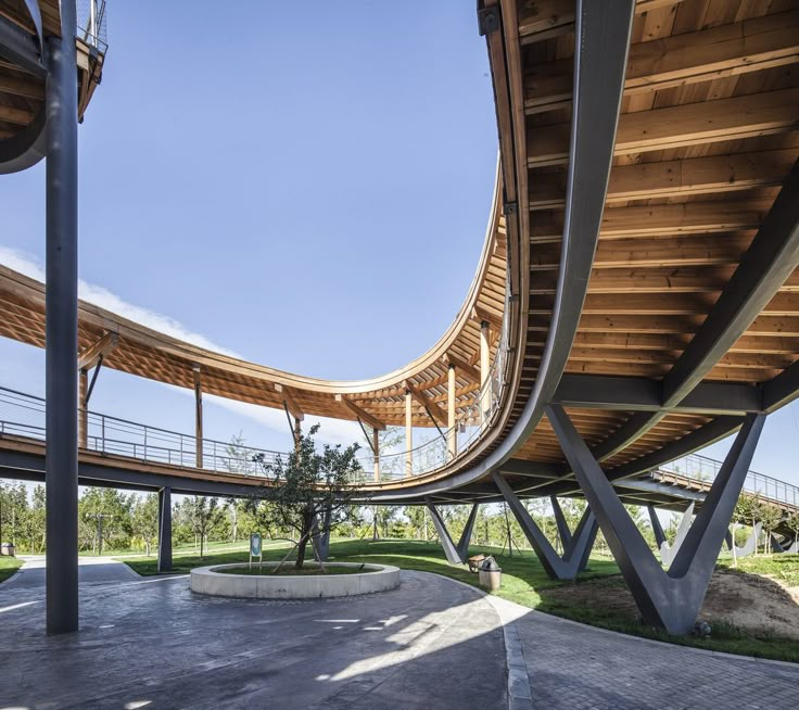 an architecturally designed walkway in the middle of a park