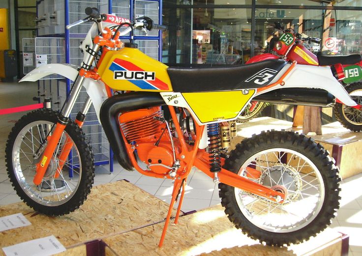 an orange and white dirt bike on display