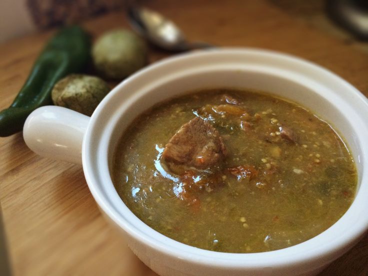 a white bowl filled with soup sitting on top of a wooden table