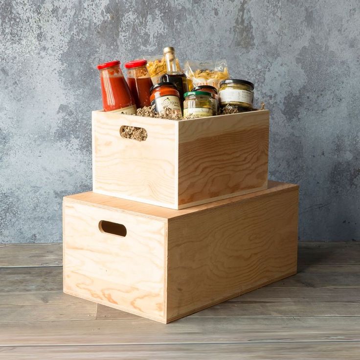 two wooden boxes are stacked on top of each other with condiments in them