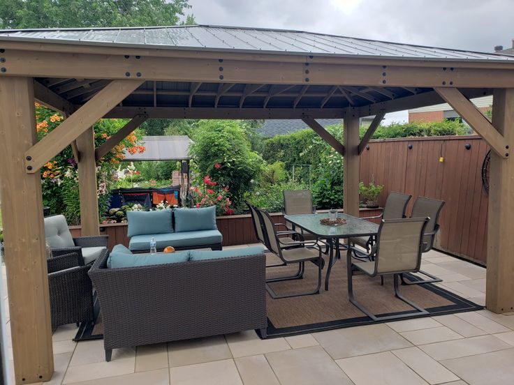 a patio covered with furniture and a wooden pergoline roof over it's outdoor dining area