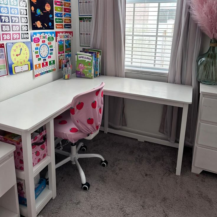 a white desk topped with a pink chair next to a window